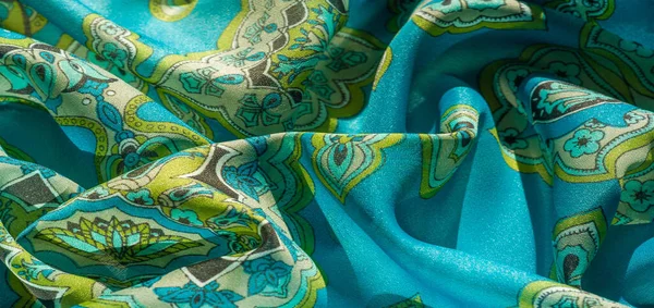 トルコ石の背景に模様が描かれた多色の絹織物です — ストック写真