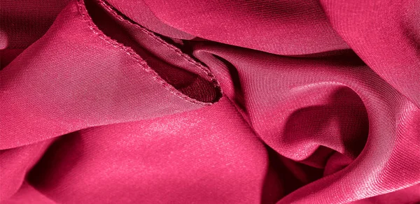 Background texture of silk fabric. This is a natural red scarf, this beautiful nylon satin made of artificial silk with a transparent hand and a wonderful sheen is perfect for your projects.