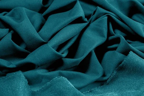 Textured, background, pattern, turquoise fabric. This is an unusual fabric that has an elegant appearance with a rich and coarse texture. It is tightly knit with designs built into the fabric itself