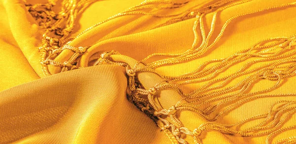 Background texture of silk fabric. This is a natural yellow scarf, this beautiful nylon satin made of rayon with a transparent hand and a wonderful sheen is perfect for your projects.