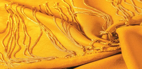 Background texture of silk fabric. This is a natural yellow scarf, this beautiful nylon satin made of rayon with a transparent hand and a wonderful sheen is perfect for your projects.