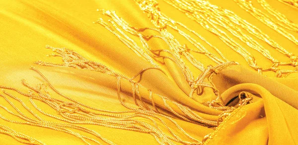 Background texture of silk fabric. This is a natural yellow scarf, this beautiful nylon satin made of rayon with a transparent hand and a wonderful sheen is perfect for your projects.