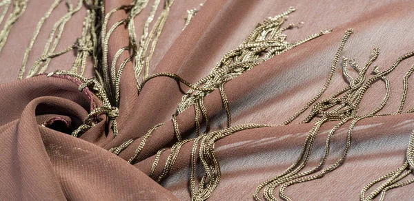 Background texture of silk fabric. This is a natural brown scarf, this beautiful nylon satin made of artificial silk with a clear hand and a wonderful sheen is perfect for your projects.