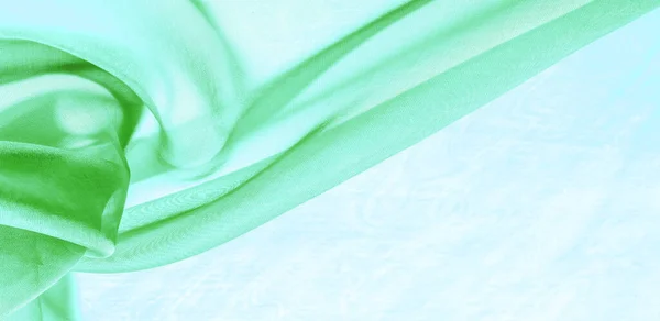 Texture of green silk fabric. It is also perfect for your design, clothes, posters. Be creative with beautiful project accents. This fabric is inspired by your inspiration.