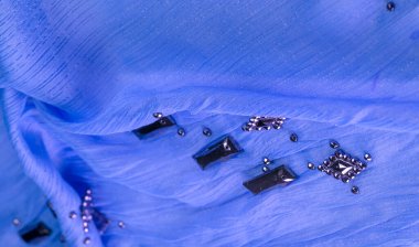 Arkaplan tasarımı dokusu, ipek desen, mavi kumaş ve dekoratif işlemeli taşlar.