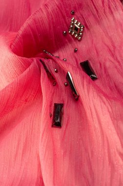 Arkaplan tasarımı dokusu, ipek desen, pembe kumaş ve dekoratif işlemeli taşlar.