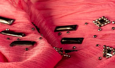 Arkaplan tasarımı dokusu, ipek desen, pembe kumaş ve dekoratif işlemeli taşlar.