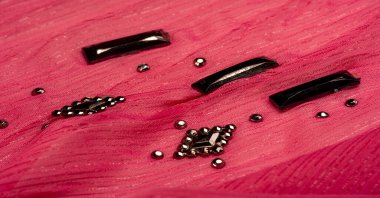 Arkaplan tasarımı dokusu, ipek desen, pembe kumaş ve dekoratif işlemeli taşlar.