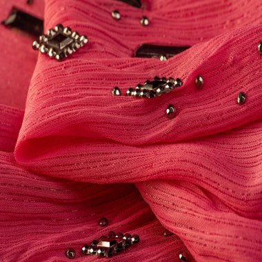 Arkaplan tasarımı dokusu, ipek desen, pembe kumaş ve dekoratif işlemeli taşlar.