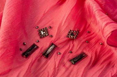 Arkaplan tasarımı dokusu, ipek desen, pembe kumaş ve dekoratif işlemeli taşlar.