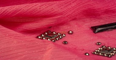 Arkaplan tasarımı dokusu, ipek desen, pembe kumaş ve dekoratif işlemeli taşlar.