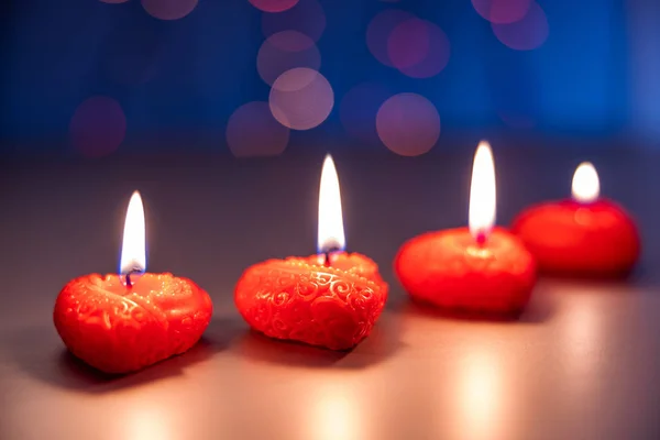 Valentines Day, a romantic still life of burning candles from hearts laid out on a blurred background, bokeh effect, shallow depth of field. Beautiful holiday picture. — ストック写真