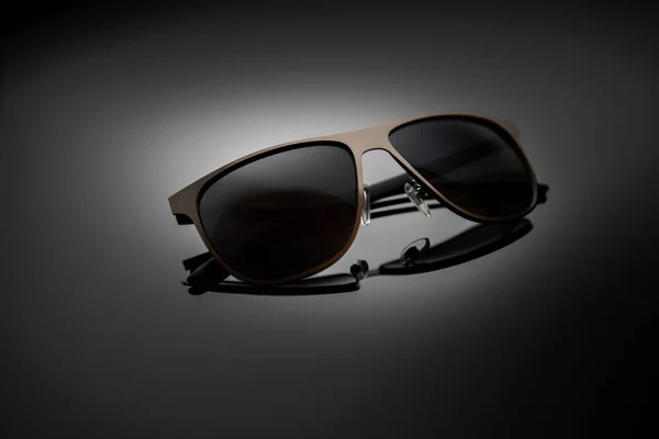 Sunglasses on a black gradient, matte background, shallow depth of field. The concept is stylish and beautiful. — Stock fotografie