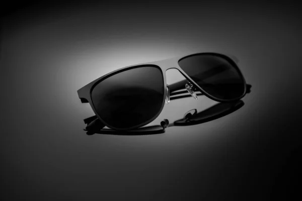 Sunglasses on a black gradient, matte background, shallow depth of field. The concept is stylish and beautiful. — Zdjęcie stockowe