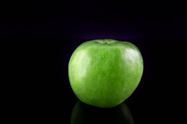 Зелене яблуко з відображенням, на чорному тлі, мала глибина різкості. Концепція, здорова їжа, спосіб життя . — стокове фото