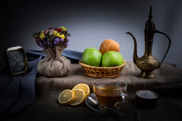 Still life, morning tea with lemons and apples in a homely atmosphere, in dark colors with bright lighting. — Stock Photo, Image