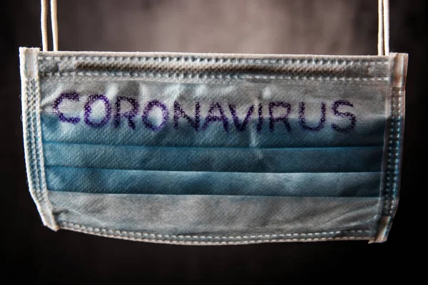 Dramatic atmosphere with surgical mask with coronavirus text written on it. 2019-nCoV virus infection in Wuhan city. Covid-19 spread around the world. Global pandemic risk due to coronavirus outbreak — Stock Fotó