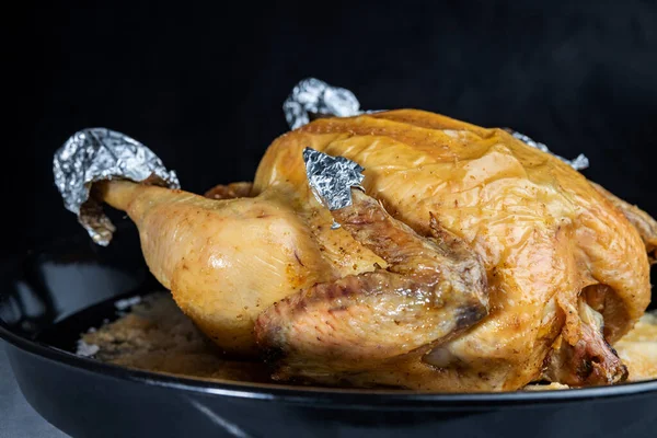 El pollo recién frito del horno casero, sobre el fondo negro, el primer plano, la profundidad superficial del campo. Concepto, cocina casera . — Foto de Stock