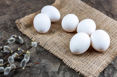 Taze organik çiftlik yumurtaları çuval bezi üzerinde, taş bir levhanın üzerinde, yakın plan, seçici odaklanma, sığ alan derinliği. Kavram, sağlıklı yiyecek, bahar dini bayramı.