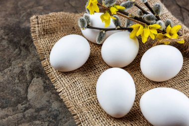 Taze organik çiftlik yumurtaları çuval bezi üzerinde, taş bir levhanın üzerinde, yakın plan, seçici odaklanma, sığ alan derinliği. Kavram, sağlıklı yiyecek, bahar dini bayramı.