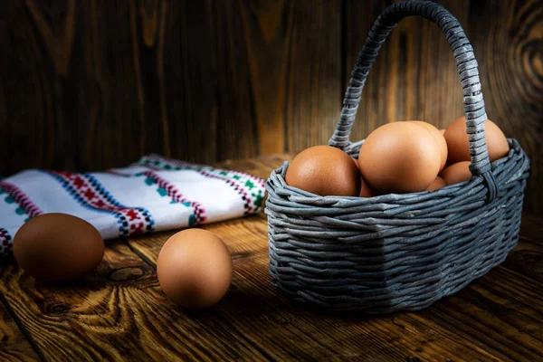 Paskalya yumurtaları tahtadan bir sepetin içinde koyu bir arka plan, sabah ışığı, yakın plan, sığ alan derinliği. Dini bayram kavramı, bahar havası..