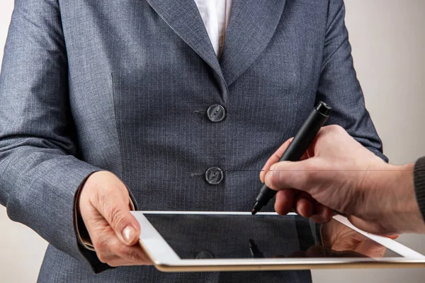 Conceito de assinatura digital, as mãos femininas estão segurando um tablet, a mão masculina está pintando, foco seletivo, profundidade rasa de campo . — Fotografia de Stock