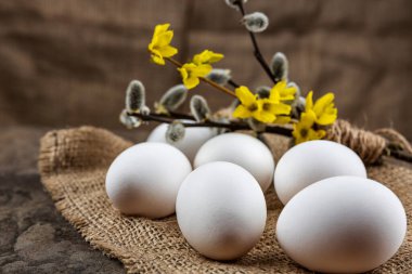Taze organik çiftlik yumurtaları çuval bezi üzerinde, taş bir levhanın üzerinde, yakın plan, seçici odaklanma, sığ alan derinliği. Kavram, sağlıklı yiyecek, bahar dini bayramı.