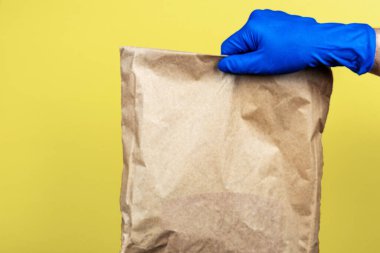 Eldivenin içinde bir kese kağıdı var. Teslimat hizmeti konsepti. Boşluğu kopyala