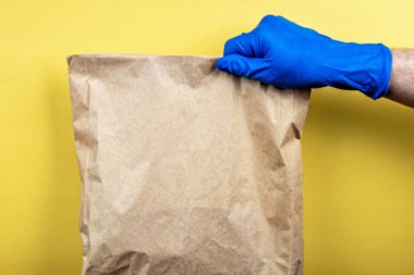 Eldivenin içinde bir kese kağıdı var. Teslimat hizmeti konsepti. Boşluğu kopyala