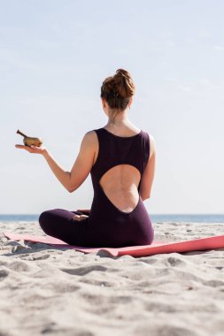 Yoga yapan kadın sabah güneşinde plajda antrenman yapıyor. 