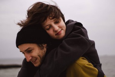 Romantik çift sahilde eğleniyor. Kumsalda koşan mutlu çift