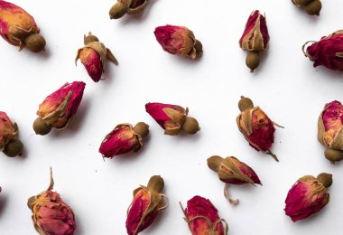 Kuru çay tomurcukları beyaz arka planda kalp şeklinde.