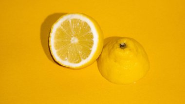 Sarı arka planda sulu bir dilim limon izole edilmiş.