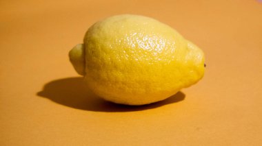 Sarı arka planda sulu bir dilim limon izole edilmiş.