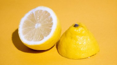 Sarı arka planda sulu bir dilim limon izole edilmiş.
