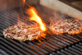 vaření hamburgery na horkém grilu s plameny