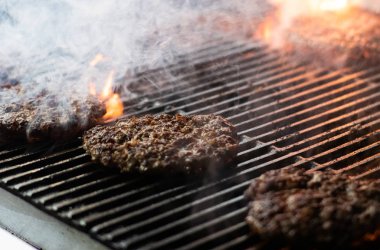 Kızarmış ızgarada alevlerle hamburger pişirmek