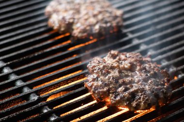Kızarmış ızgarada alevlerle hamburger pişirmek