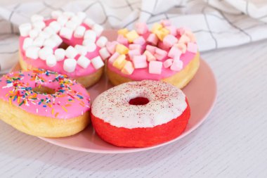 Masada renkli çörekler var. Manzarayı kapat. Boşluğu kopyala