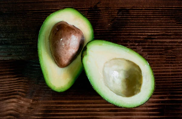 isolated avocado on a dark wood and white background. selective focus