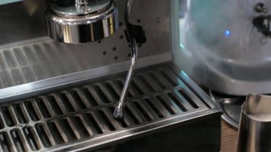 Barista iş başında. Kahve ve kakao yapma süreci. Bir bardak köpüklü süt. Elektrikli Öğütücü kahve çekirdeğini filtre tutacağına öğüttü.