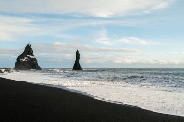 Kışın İzlanda 'daki kara kumsalda gün doğumu
