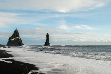 Kışın İzlanda 'daki kara kumsalda gün doğumu