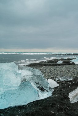 İzlanda 'daki elmas plajı ya da Jokulsarlon Buzdağı plajı. İzlanda 'da volkanik plajda eriyen kristal buz.