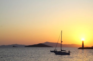 Gün batımında deniz manzarası. Sahildeki deniz feneri. Deniz kenti Turgutreis ve muhteşem gün batımları