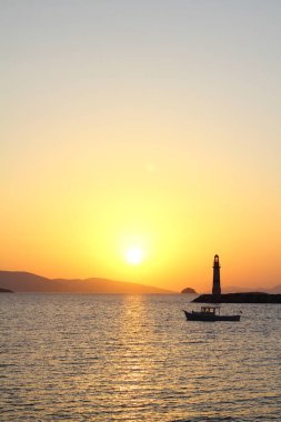 Gün batımında deniz manzarası. Sahildeki deniz feneri. Deniz kenti Turgutreis ve muhteşem gün batımları
