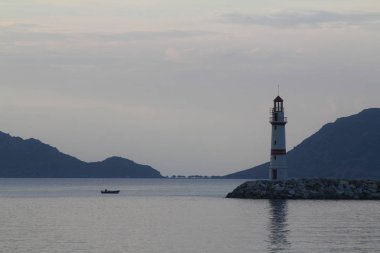Gün batımında deniz manzarası. Sahildeki deniz feneri. Deniz kenti Turgutreis ve muhteşem gün batımları