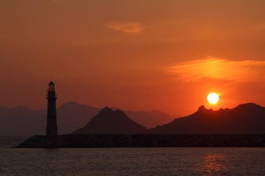 Gün batımında deniz manzarası. Sahildeki deniz feneri. Deniz kenti Turgutreis ve muhteşem gün batımları