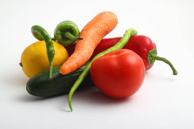 Beyaz arka planda taze sebzeler. Limon, domates, biber, salatalık ve havuç.. 