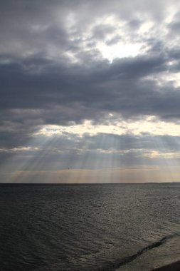 Pitoresk bulutlar deniz yoluyla ışık saçan güneş ışınları. Güneş, bulutların ve su, deniz fotoğraf.